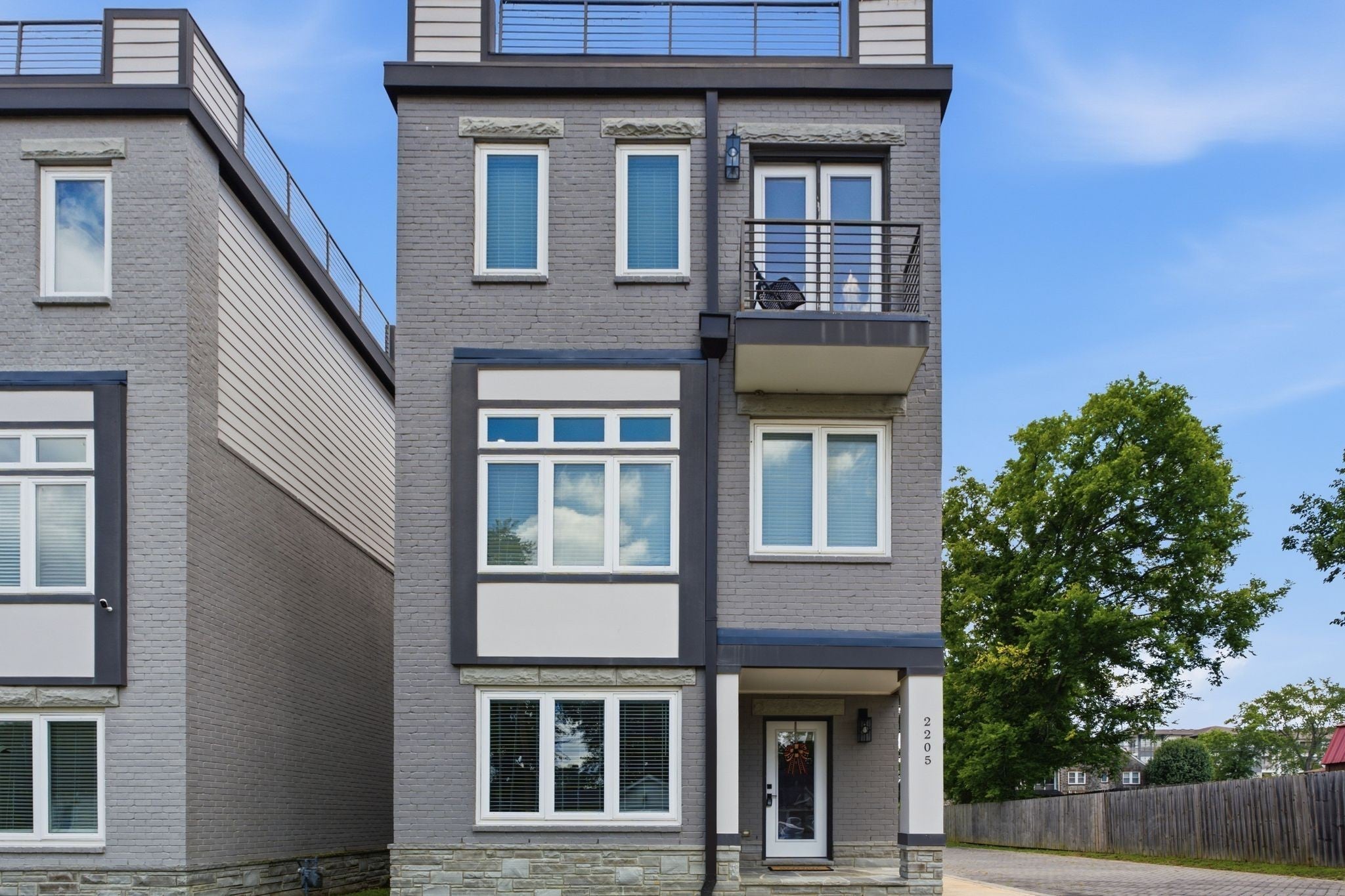 3-bed condo for sale in Old Hickory, TN 37138, 2205 Dabbs Ave Three-story townhome at 2205 Dabbs Ave, Old Hickory, TN 37138, with gray brick facade, dark trim and a small balcony above the entry