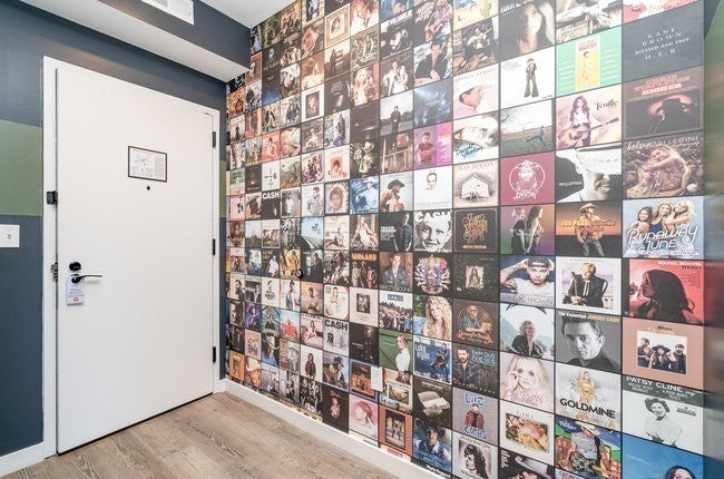 0-bed condo for sale in Nashville, TN 37203, 50 Music Sq W 316 Entry hall with a wall of framed album covers and a white door with wood-look flooring