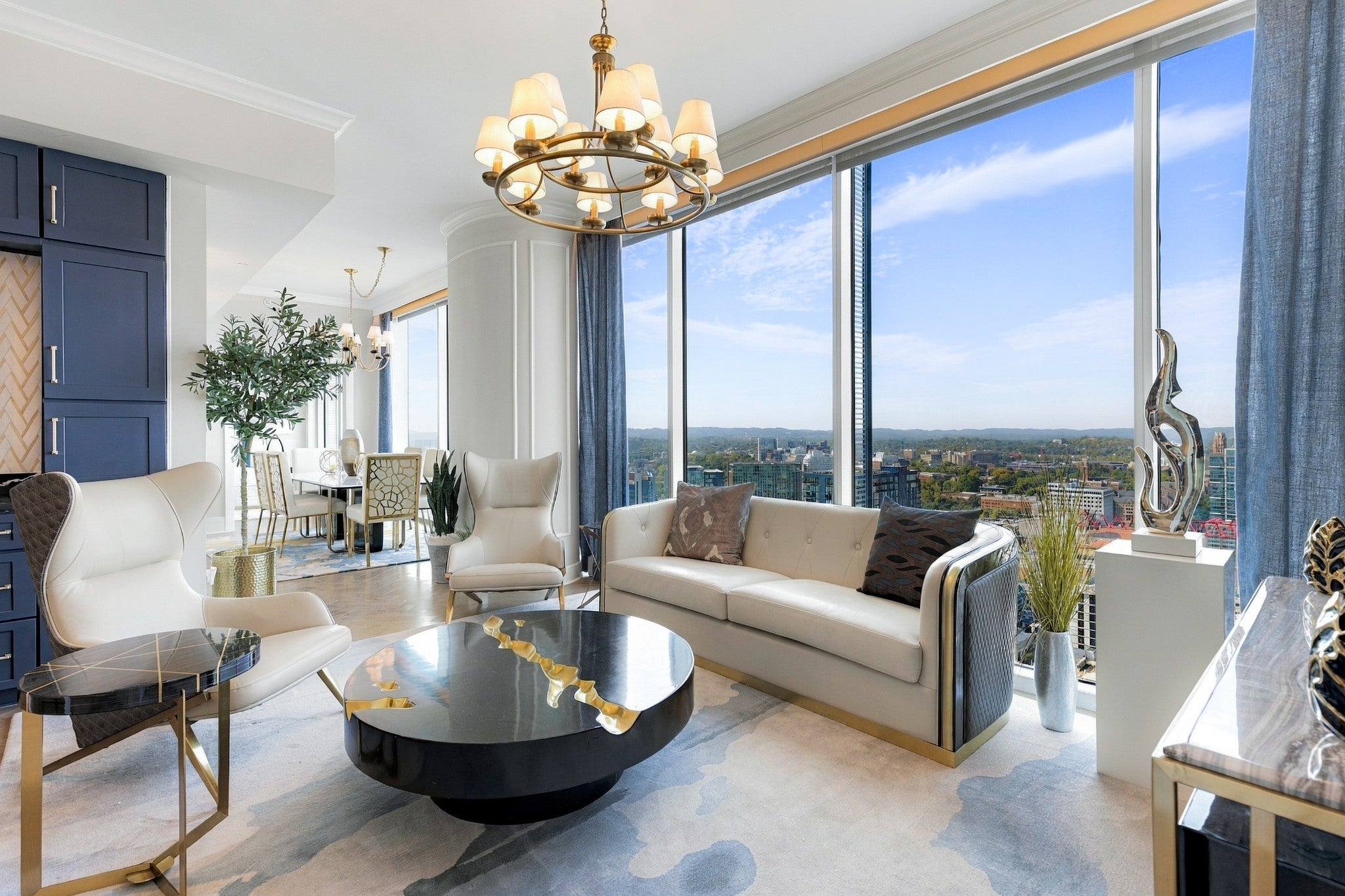 2-bed condo for sale in Nashville, TN 37203, 1616 West End Ave 3001 Living room with cream sofa, white armchairs, a black round coffee table and floor-to-ceiling windows over the city