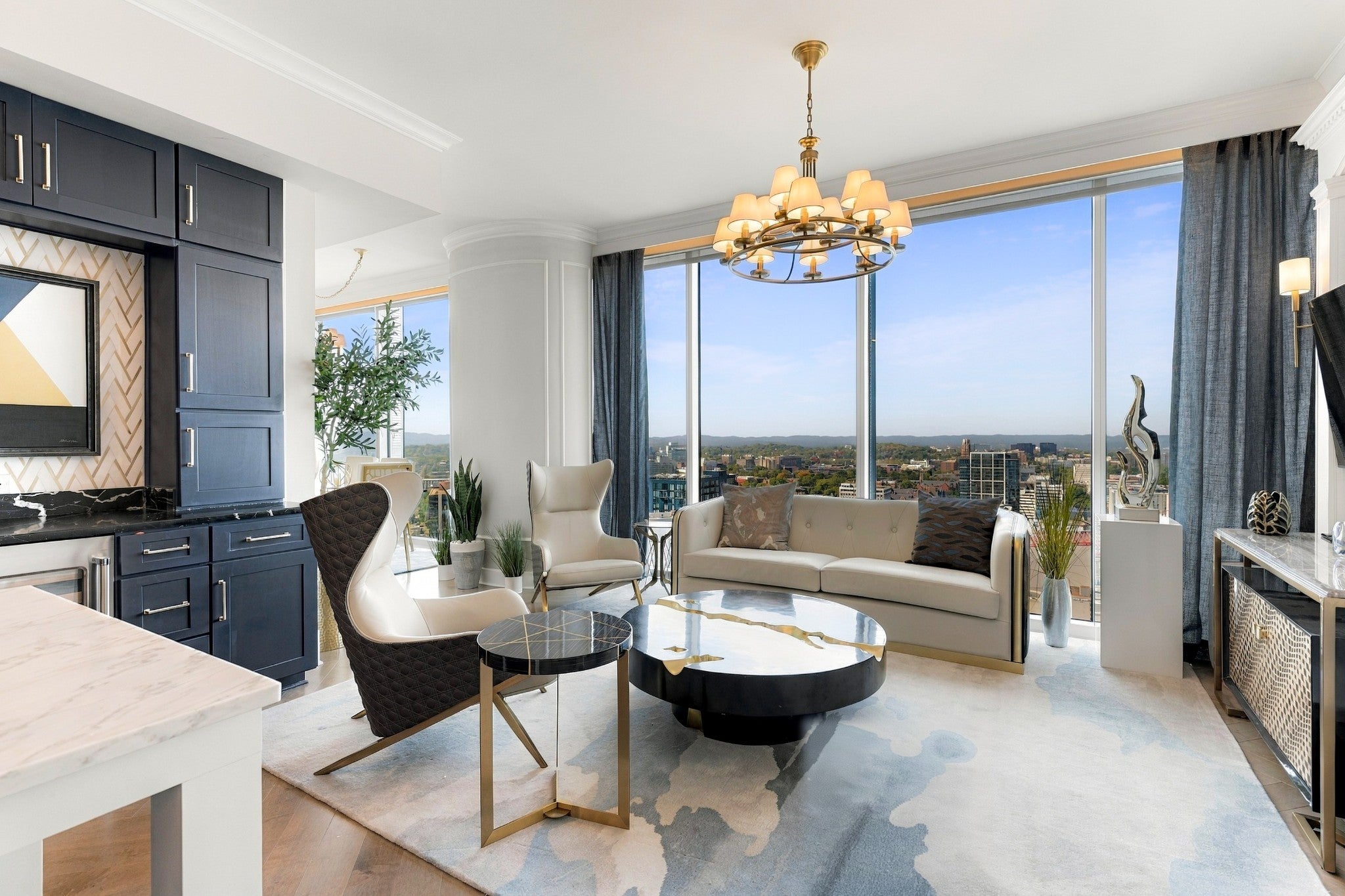 2-bed condo for sale in Nashville, TN 37203, 1616 West End Ave 3001 Living room with white sofa and armchairs, a black coffee table and a view of the city through tall windows