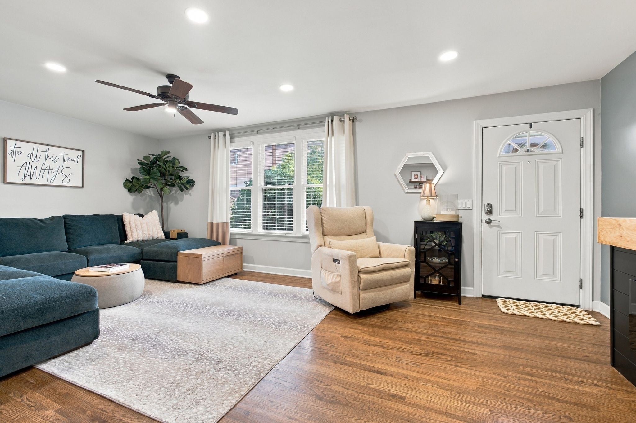 3-bed home for sale in Nashville, TN 37211, 613 Tobylynn Dr Living room with a teal sectional sofa, a recliner chair, a ceiling fan and a white front door with an arched window