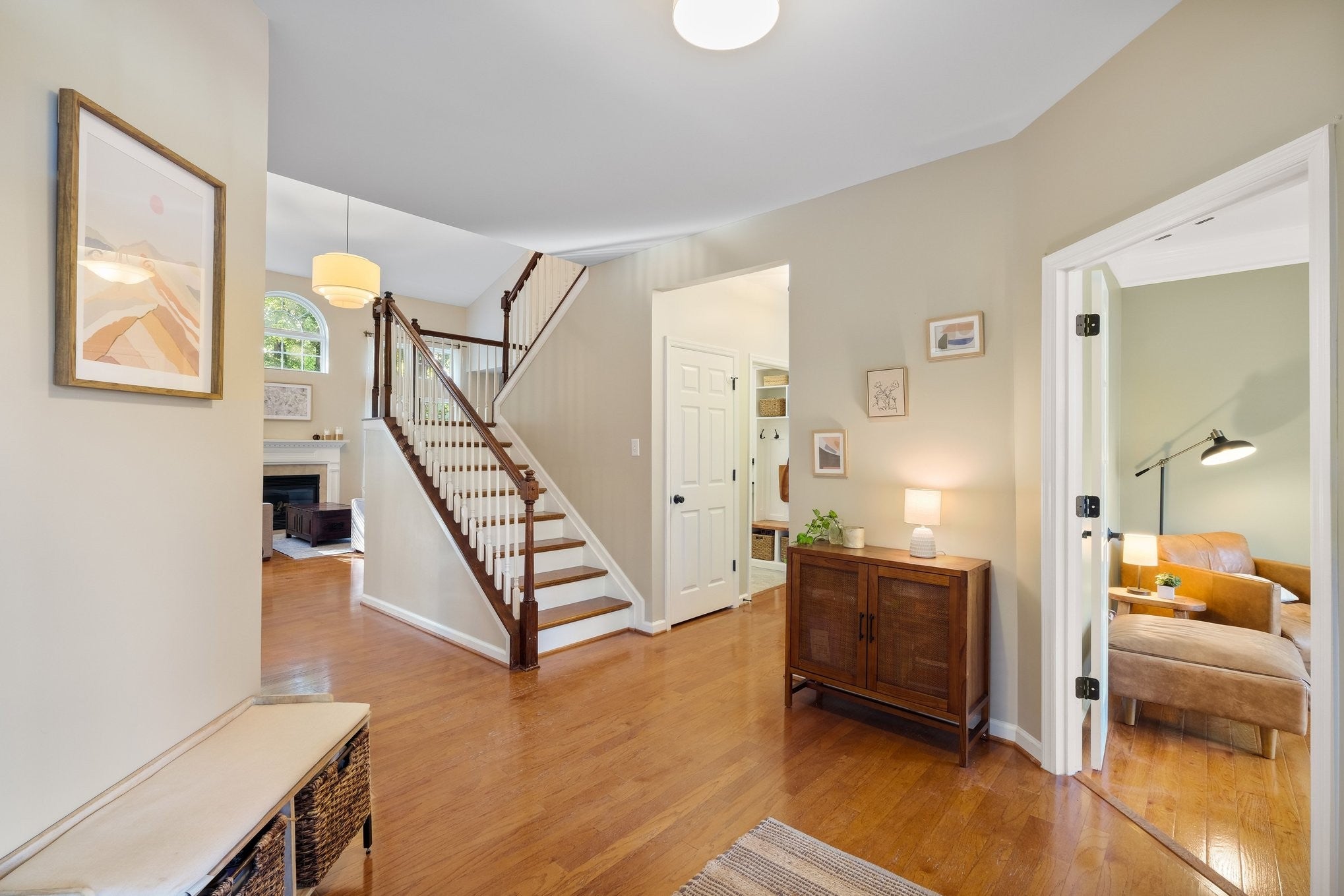 5-bed home for sale in Franklin, TN 37064, 403 William Wallace Dr Foyer with wood floors and a staircase with white balusters and wood handrail, leading toward a fireplace and a sitting room
