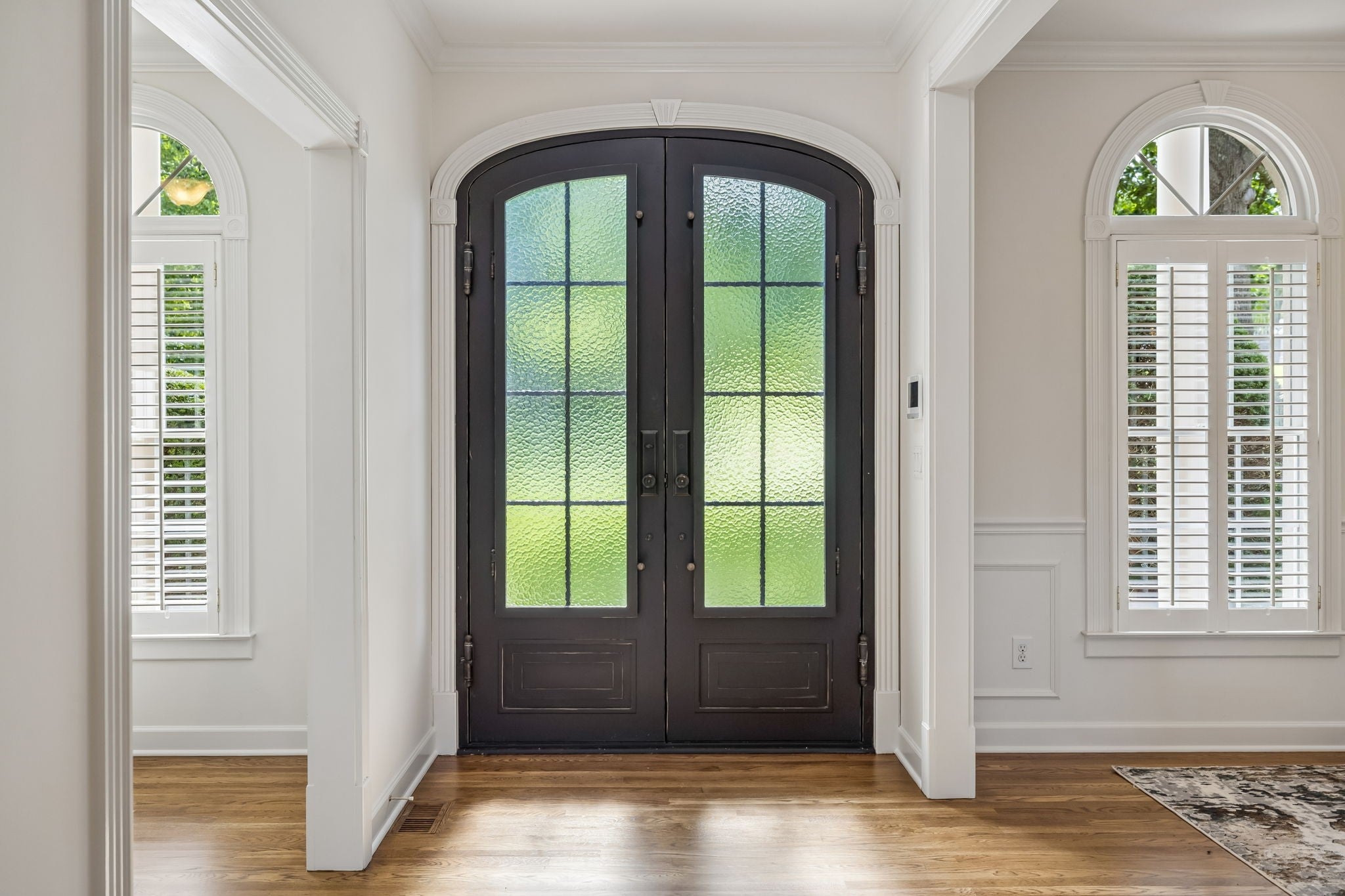4-bed home for sale in Brentwood, TN 37027, 1521 Puryear Pl Entry foyer with dark arched double doors, wood floors and white trim, with shuttered arched windows at each side
