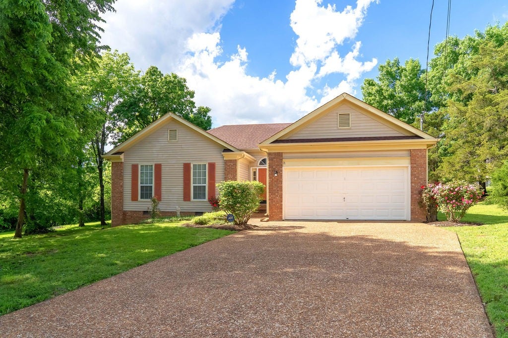 3-bed home for sale in Antioch, TN 37013, 1305 Joust Ct Single-family ranch home at 1305 Joust Ct, Antioch, TN 37013, with tan vinyl siding, brick accents and a two-car garage at the end of a driveway