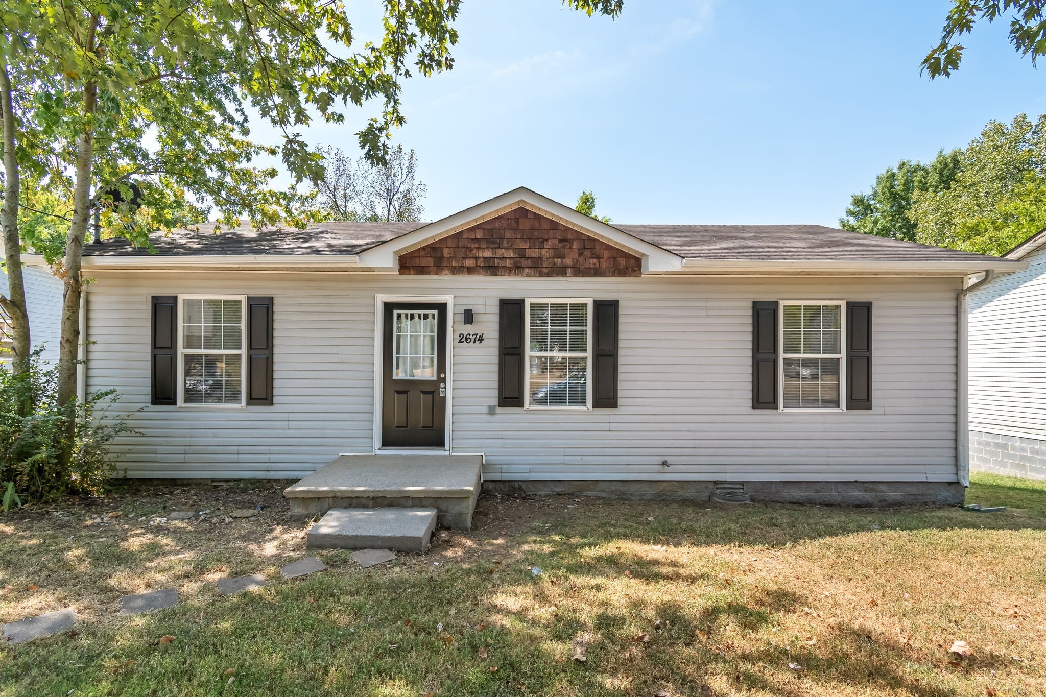 3-bed home for sale in Nashville, TN 37207, 2674 Old Matthews Rd Front entry with a dark door, small paned glass window and a concrete stoop with stepping stones leading to the walk