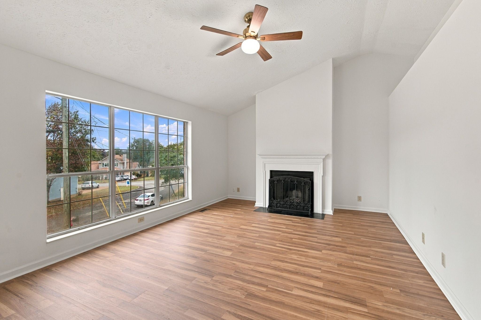 3-bed home for sale in Antioch, TN 37013, 1109 Burlingame Ct Living room with wood-look flooring, a corner fireplace, a vaulted ceiling with a ceiling fan and a large front window