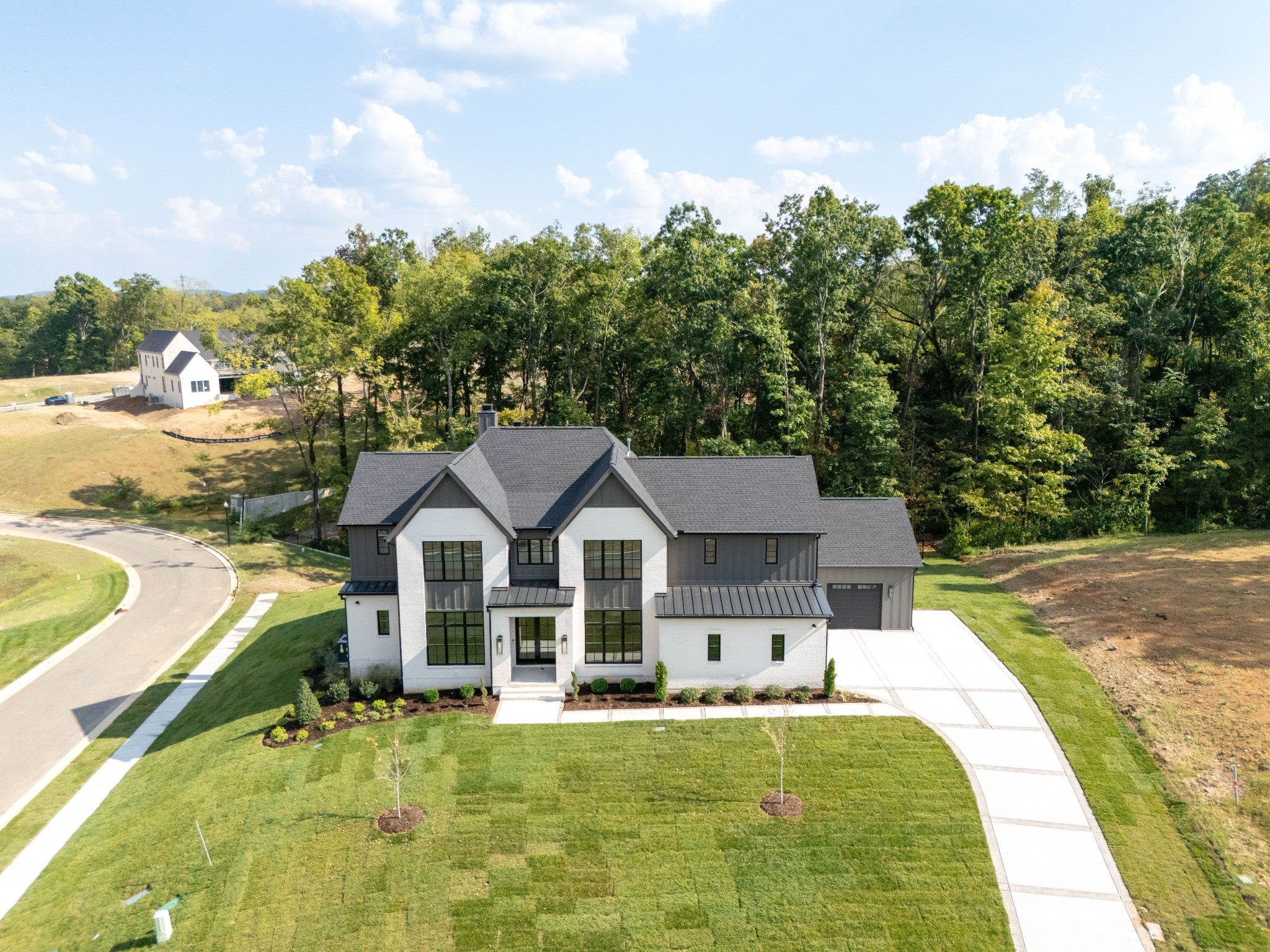 5-bed home for sale in Brentwood, TN 37027, 9405 Dewaal Ridge Two-story home at 9405 Dewaal Ridge, Brentwood, TN 37027, with white brick and dark board siding under a dark roof, seen from above