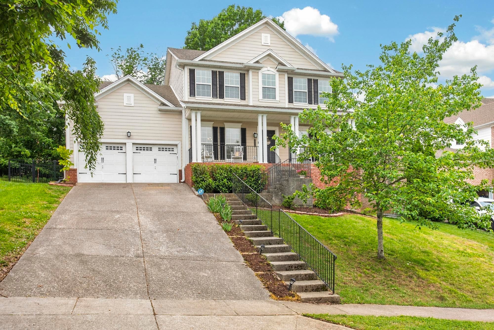 4-bed home for sale in Nolensville, TN 37135, 4713 Jobe Trl Front exterior of a two-story house with beige siding, a brick base, a covered porch and a long concrete driveway