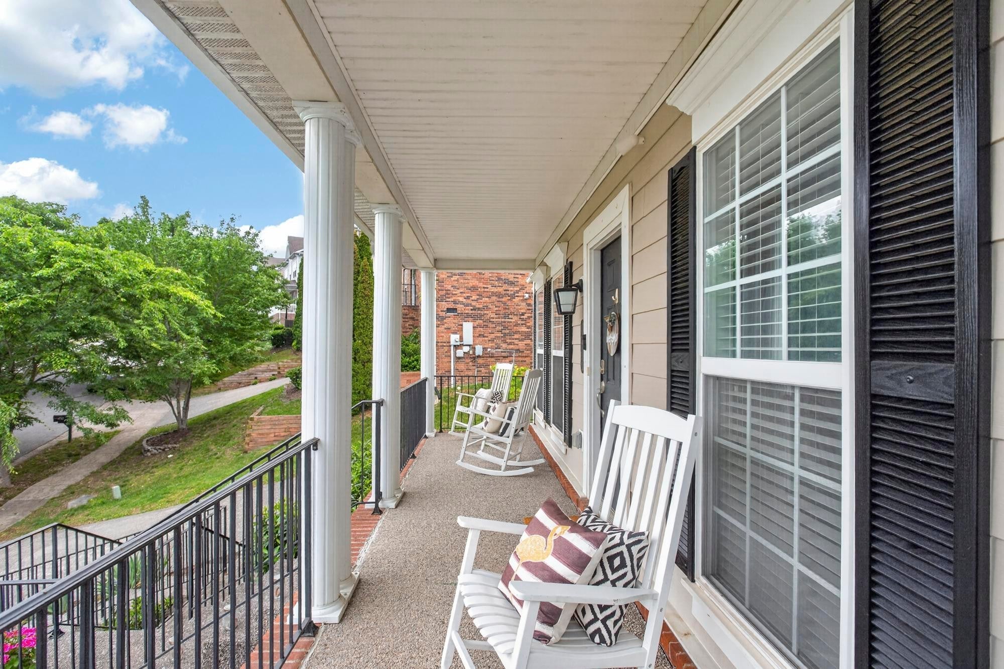 4-bed home for sale in Nolensville, TN 37135, 4713 Jobe Trl Covered front porch with white rocking chairs, white columns and black railing overlooking the street and trees