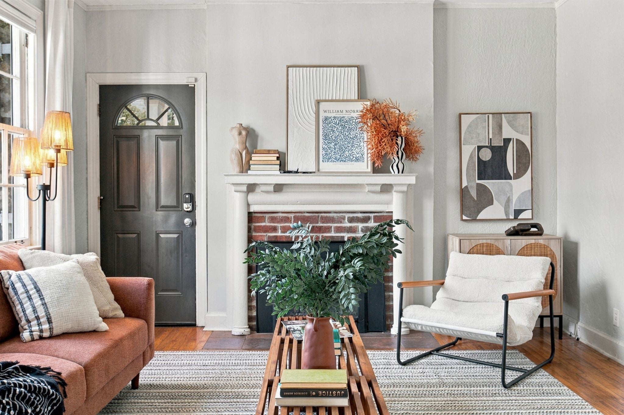 4-bed home for sale in Nashville, TN 37212, 2003 Sweetbriar Ave Living room corner with a brick fireplace, white mantel, dark front door with a fanlight and framed wall art
