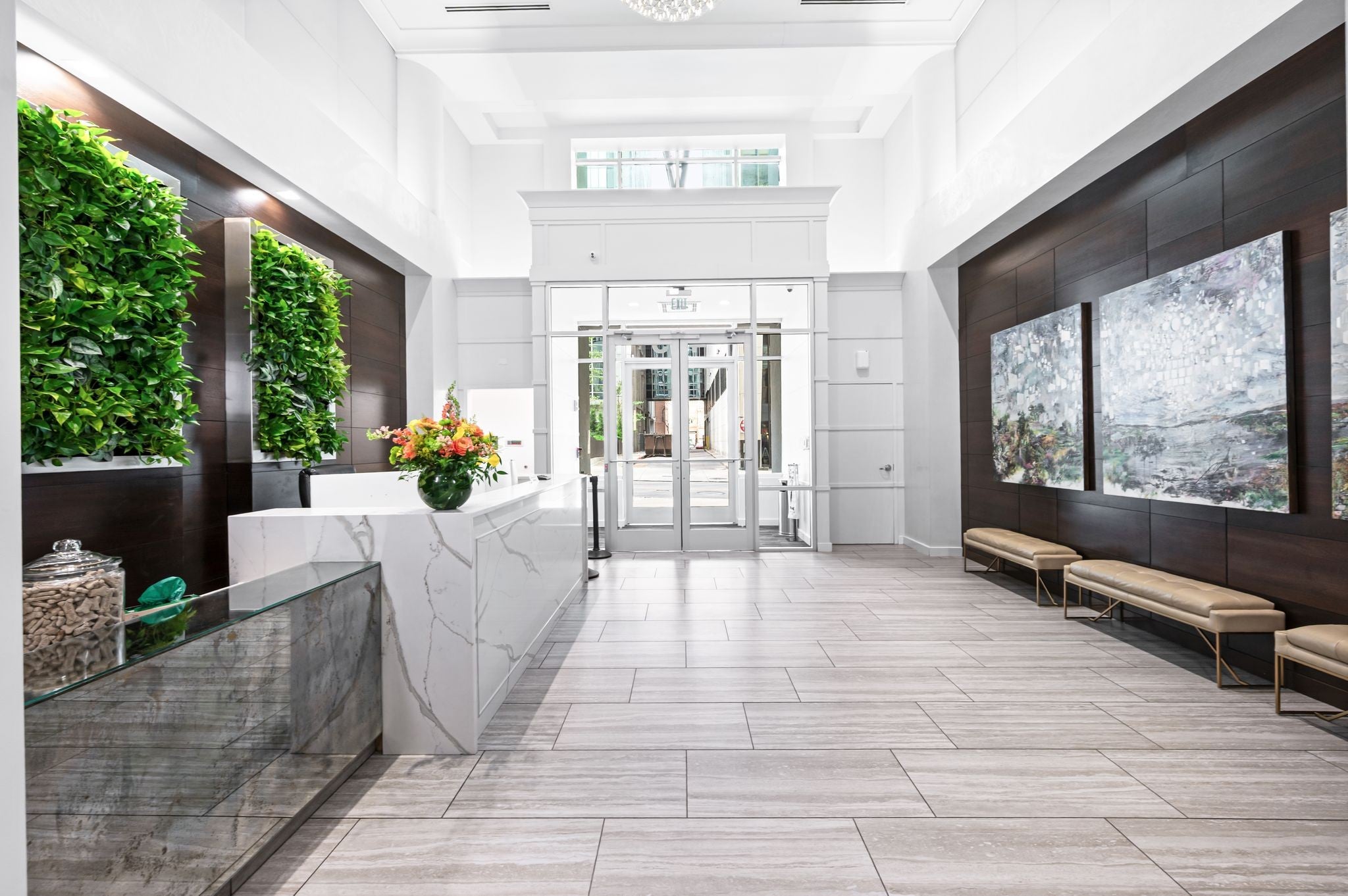 Lobby with a white stone reception counter, living green wall panels and a glass display case