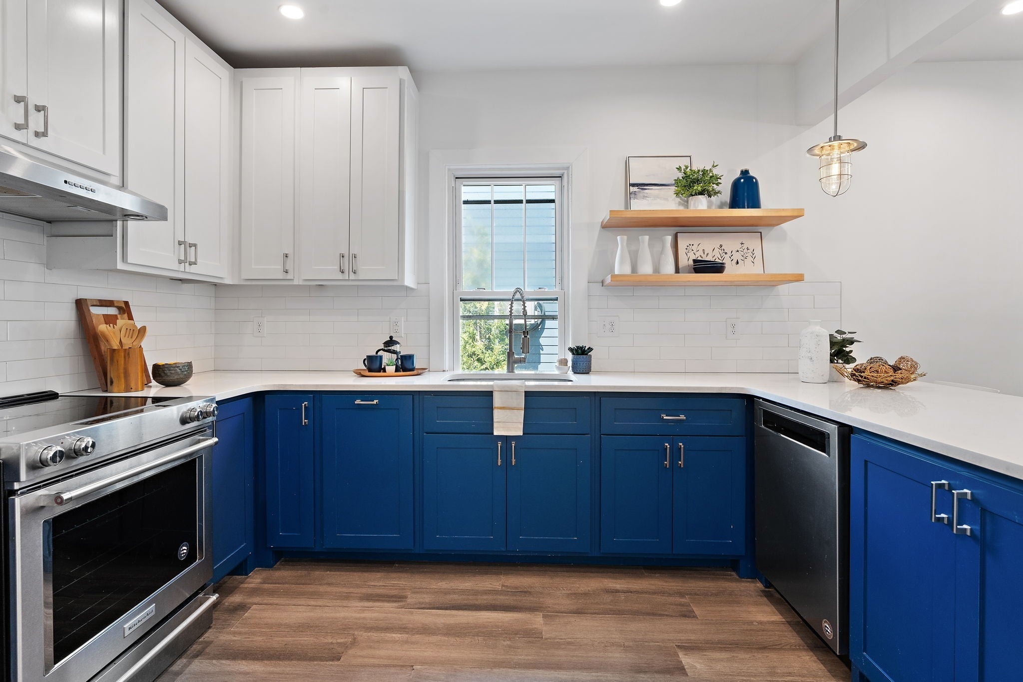 Kitchen with blue lower cabinets, white upper cabinets, stone countertops, open shelving and stainless steel appliances