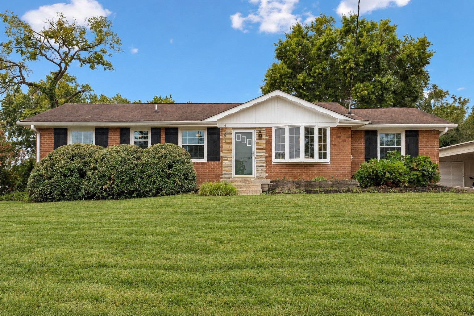 3-bed home sold in Nashville, TN 37216, 1996 Upland Dr Single-story brick ranch home at 1996 Upland Dr, Nashville, TN 37216, with a white gable over the entry and dark shutters under a clear sky