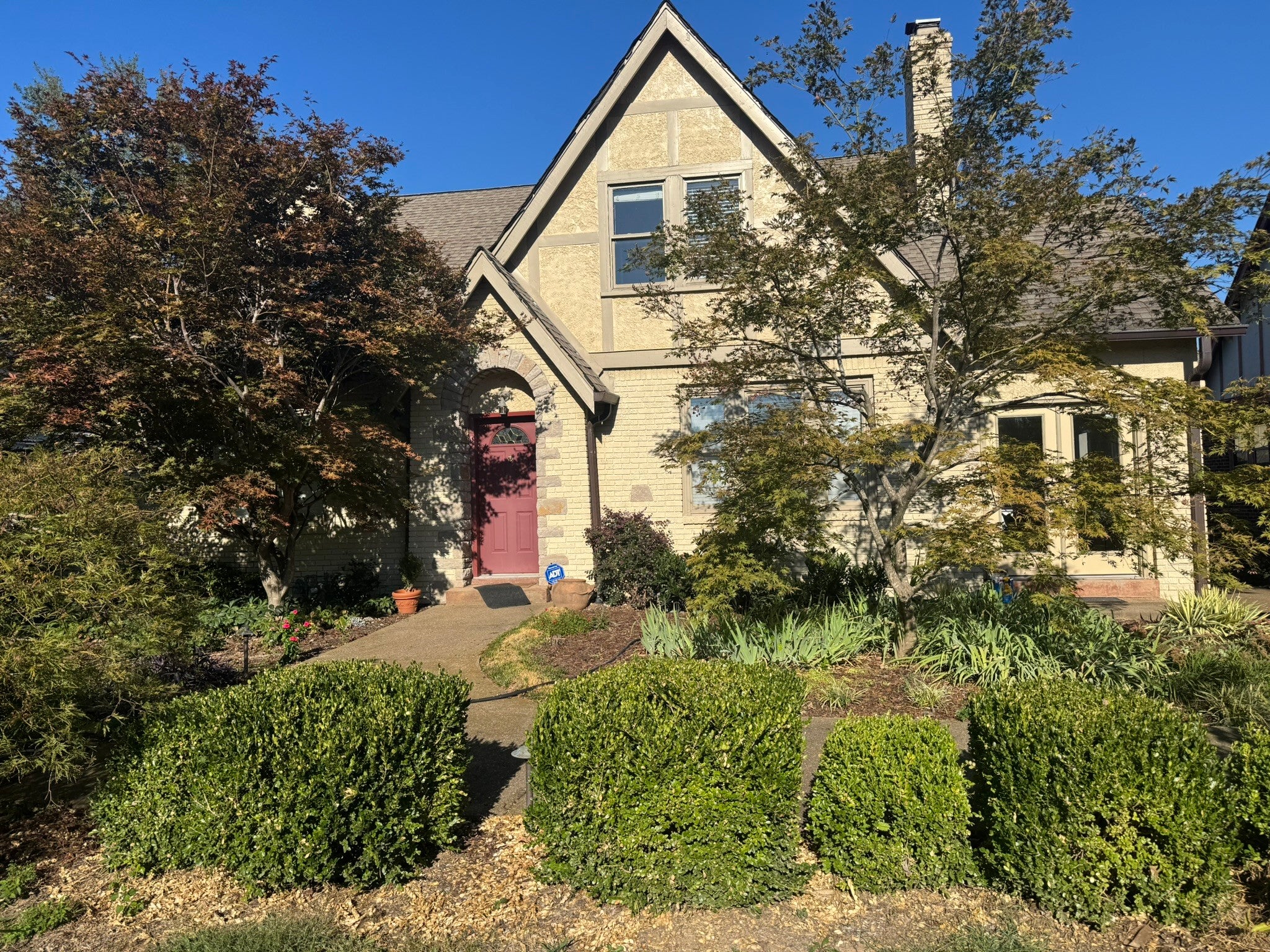 3-bed home for sale in Nashville, TN 37205, 230 Cherokee Rd Two-story Tudor home at 230 Cherokee Rd, Nashville, TN 37205, with cream stone facade, a steep gable and a red front door under an arched entry