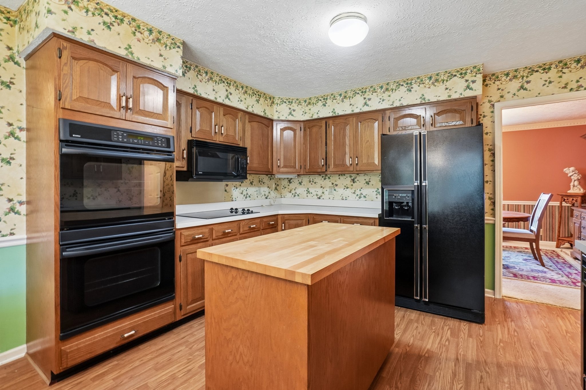 3-bed home for sale in Antioch, TN 37013, 3921 Hillshire Dr Kitchen with a wood-top island, double wall ovens, black refrigerator and an open doorway to the dining room