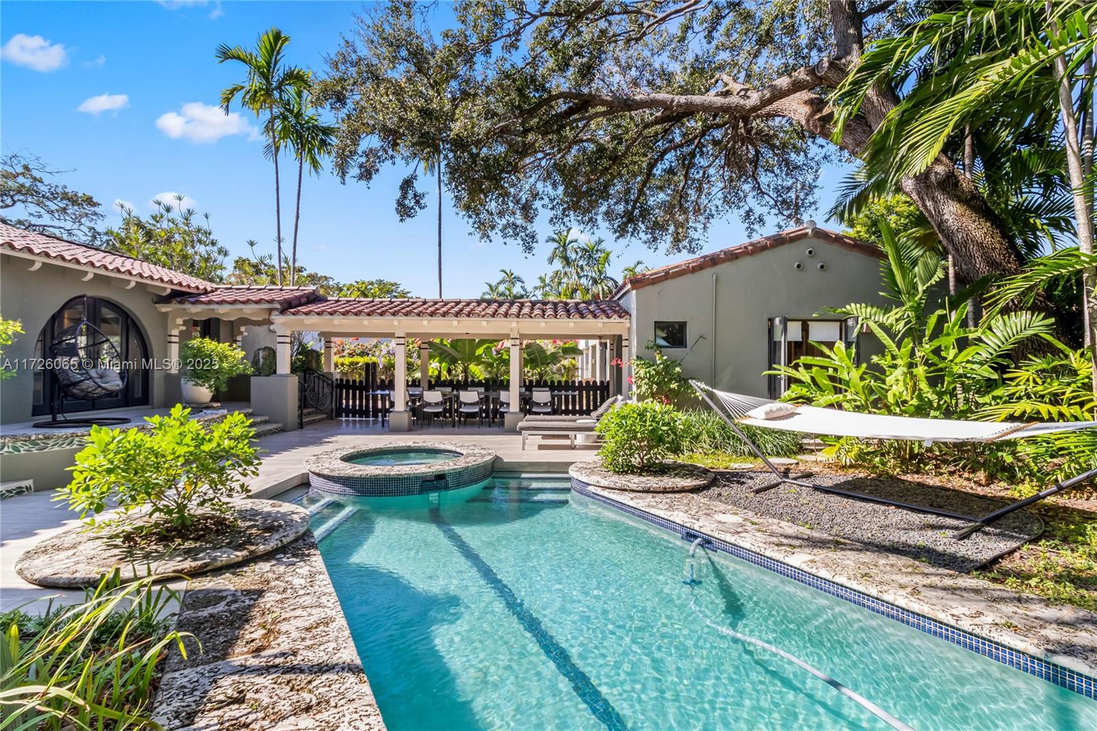 First time available in 18 years. This rare Mediterranean Revival home designed by famed architecture firm of Kiehnel and Elliott (Coral Gables Congregational Church, Scottish Rite Masonic Temple, Coral Gables Elementary School & numerous distinguished residences in Miami) has been comprehrensively updated w/luxe finishes. Main house consists of 3 bedrooms, 2.5 baths + a guest house w/1 bedroom & 1 bath. Chef's kitchen equipped with Sub Zero & Meile appliances, Poggenpohl cabinetry & quartz counter tops. All baths appointed w/unique imported stone & tiles. Newer roof & impact windows/doors. Oak hardwood & tile floors throughout. 2 car garage. Award winning lap pool, hot tub & lush tropical gardens sited on large 12,500 sq ft walled & gated lot on quiet, 1 block long low traffic street.