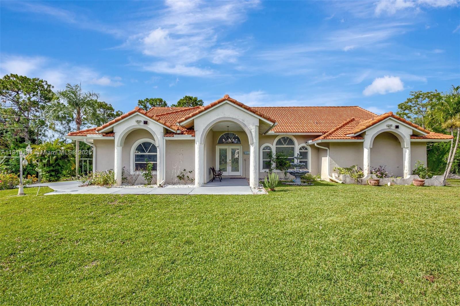 Experience luxury living surrounded by nature in this beautifully upgraded 4-bedroom, 2-bath home on 1.14 serene acres in Loxahatchee. Filled with natural light, it features elegant bathrooms and a spa-style master suite with a spacious walk-in closet. New tile flooring complements an open layout with a breakfast bar. Ideal for entertaining, the expansive covered patio and pergola overlook a fully fenced yard with double-gated entry—perfect for RV, boat storage, or equestrian use. Extras include mango and avocado trees, two wells, a sprinkler system, 2 car garage, ADT security, new roof (2019). Conveniently located minutes from shopping, dining, Lion Country Safari, and top hospitals, this home offers a rare blend of comfort, privacy, and upscale features. Make it yours today!