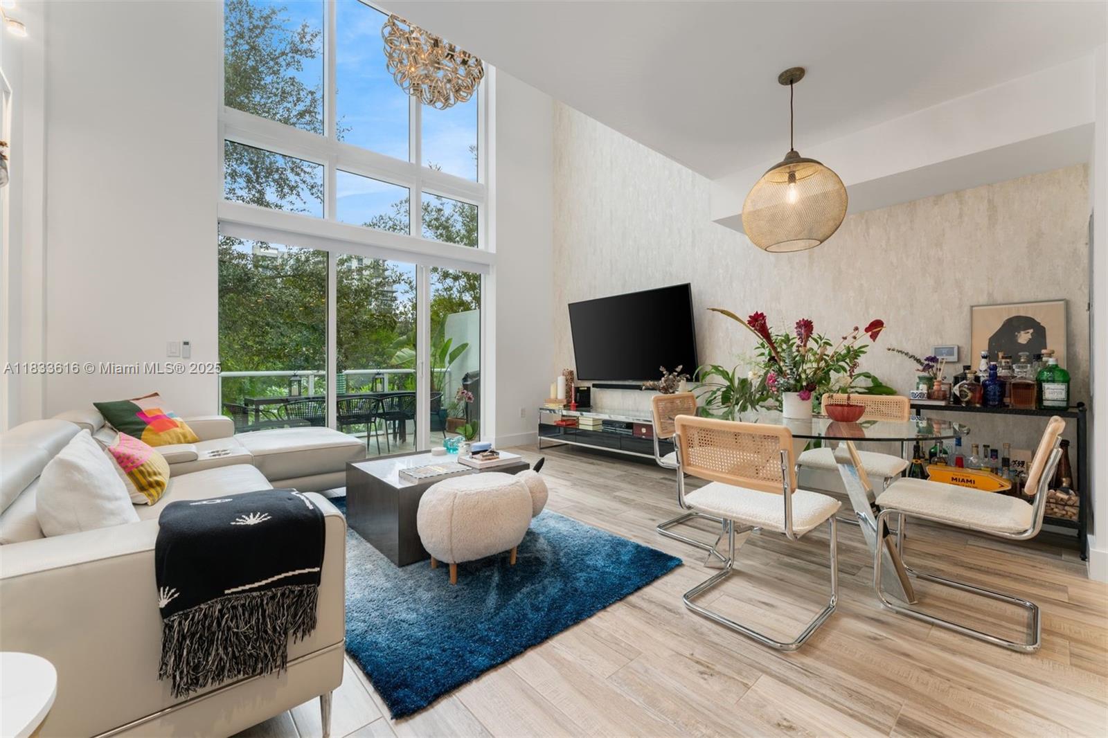 Modern & meticulously upgraded, this turnkey townhouse offers a rare combination of privacy, outdoor living, and low-maintenance. TH 105 @ One Bay features a private rooftop with city views, a private garage, and soaring double-height ceilings that provide the natural light you crave. Inside, you’ll find a well-appointed open kitchen, custom wallpaper & light fixtures throughout, and several add'l mindful upgrades such as a reverse osmosis water purification system, automatic window treatments, and custom closets. Lush greenery surrounds the downstairs balcony encouraging a sense of calm and tranquility. Brand-new electronic awning just installed on rooftop. One Bay is a gated community steps from the Design District ideal for those seeking convenient, low-maintenance turnkey luxury.