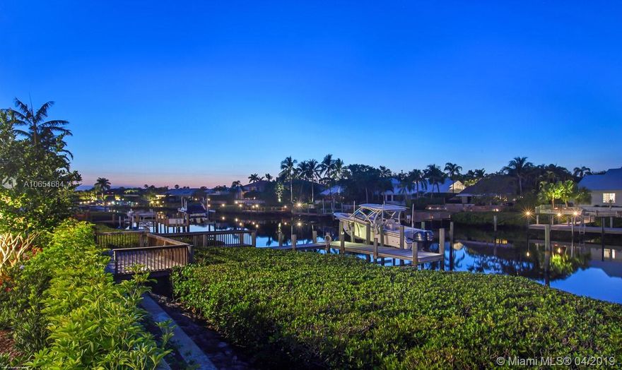 THIS ELEGANT HOUSE IS A COMPLETE SHOW STOPPER in prestigious Admirals Cove. This property has everything from the golf course in the front yard to the water in the rear. Inside this beautiful home you will find a spacious foyer, a split bedroom layout, vaulted ceilings, custom built-ins, walk-in closets, hurricane impact glass, recessed lighting, beautiful chandeliers, even an elevator. You will love the gourmet chef's kitchen offering an open design with a large cook island, stunning counter-tops, top of the line appliances, beautiful cabinetry, and a large eat-in area with views of the pool. The rear exterior of this property is even more impressive offering a covered loggia w/ full summer kitchen, TV, fireplace, and electric screen. A must see and will not last.