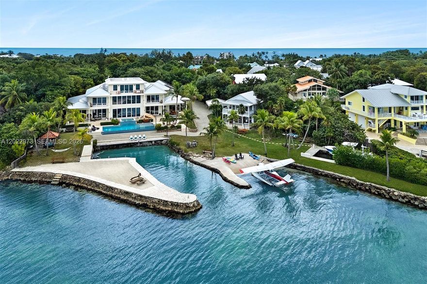 Welcome to Serenity Cay, an exquisite Balinese-inspired estate where tranquility and luxury meet the endless beauty on the Florida Bay. A true masterpiece of engineering and design, this sprawling waterfront residence on nearly four acres offers an unparalleled blend of tropical elegance, sophisticated craftsmanship, and modern luxury. An expansive infinity-edge pool blends seamlessly into the sparkling waters of the bay while lush gardens create a serene oasis. The home's architecture showcases graceful, custom finishes and rich hardwoods, all hallmarks designs that evoke the spirit of the Islands. The interior is a seamless fusion of open-concept living spaces and private retreats. Soaring vaulted ceilings and vast windows invite abundant natural light and spectacular views of the bay, creating an indoor-outdoor flow. The primary suite serves as your personal sanctuary, complete with private terrace, spa-inspired bathroom, and walk-in closets fit for a connoisseur of fine living. Each guest has direct access to outdoor spaces and views. A versatile bunk room/media center sits just off the west wing of the home. The charming guest house is the perfect complement to the main home, nestled in its own secluded on site location this delightful addition exudes a warm, welcoming ambiance ideal for hosting guests, or as a private office or creative studio.