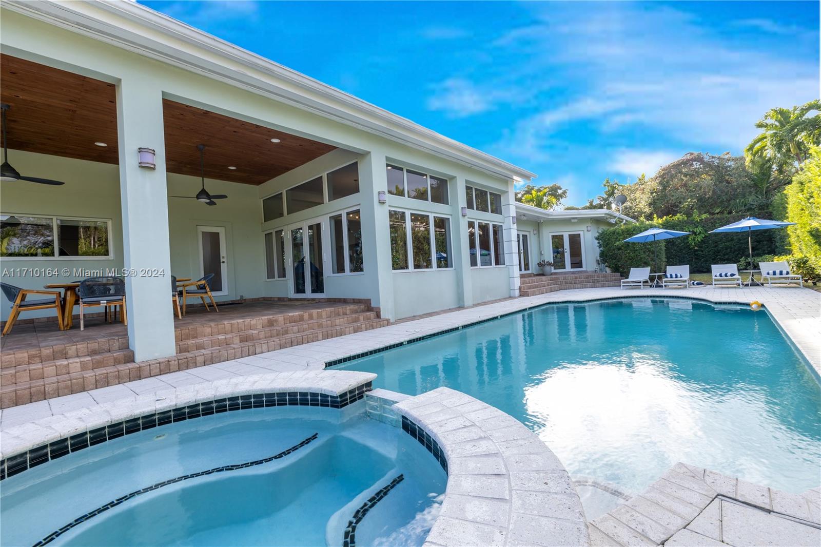 Experience luxurious living in this updated mid-century modern home, available for seasonal rent (max 6 months). Natural light fills every corner, highlighting the elegant hardwood and terrazzo floors, expansive master suite, and gourmet kitchen with granite countertops. Hurricane impact windows and updated systems offer comfort and security. Step outside to a lush tropical oasis featuring a covered patio, sparkling pool, and serene landscaping on an expansive lot. A truly exceptional rental opportunity! - Pets ok.