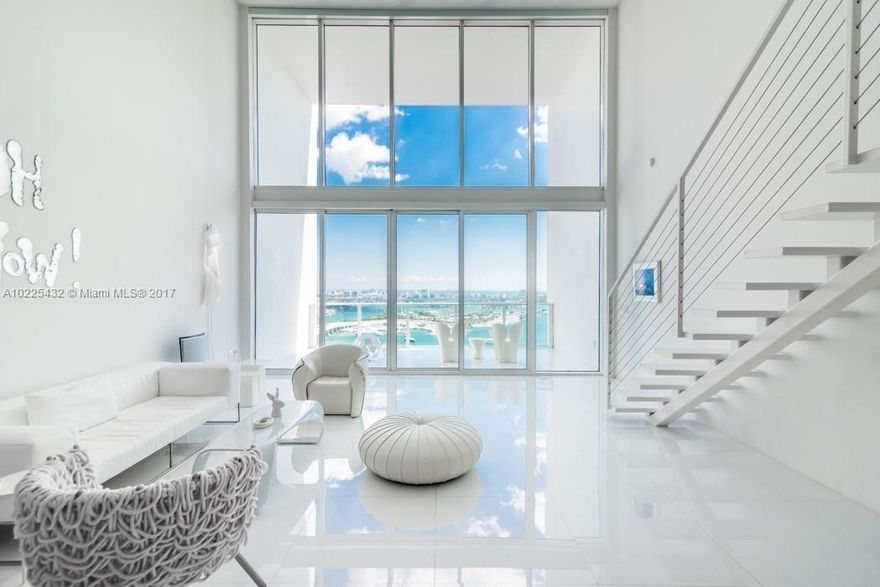 True definition of modern at Ten Museum Park. This 1949 sq/ft sky loft w/ 2bds/2.5ba & 20' walls of glass w/ sweeping views of government cut, South Beach & the Atlantic. This cutting edge loft is finished to perfection w/ white glass flooring, a stainless kitchen island, upgraded bathrooms and a floor to ceiling Mariyln Mitner photo in the dining area. Upgrades include motorized solar shades, full size LG washer & Dryer, recessed lighting, air conditioned storage, 2 parking spaces & more.