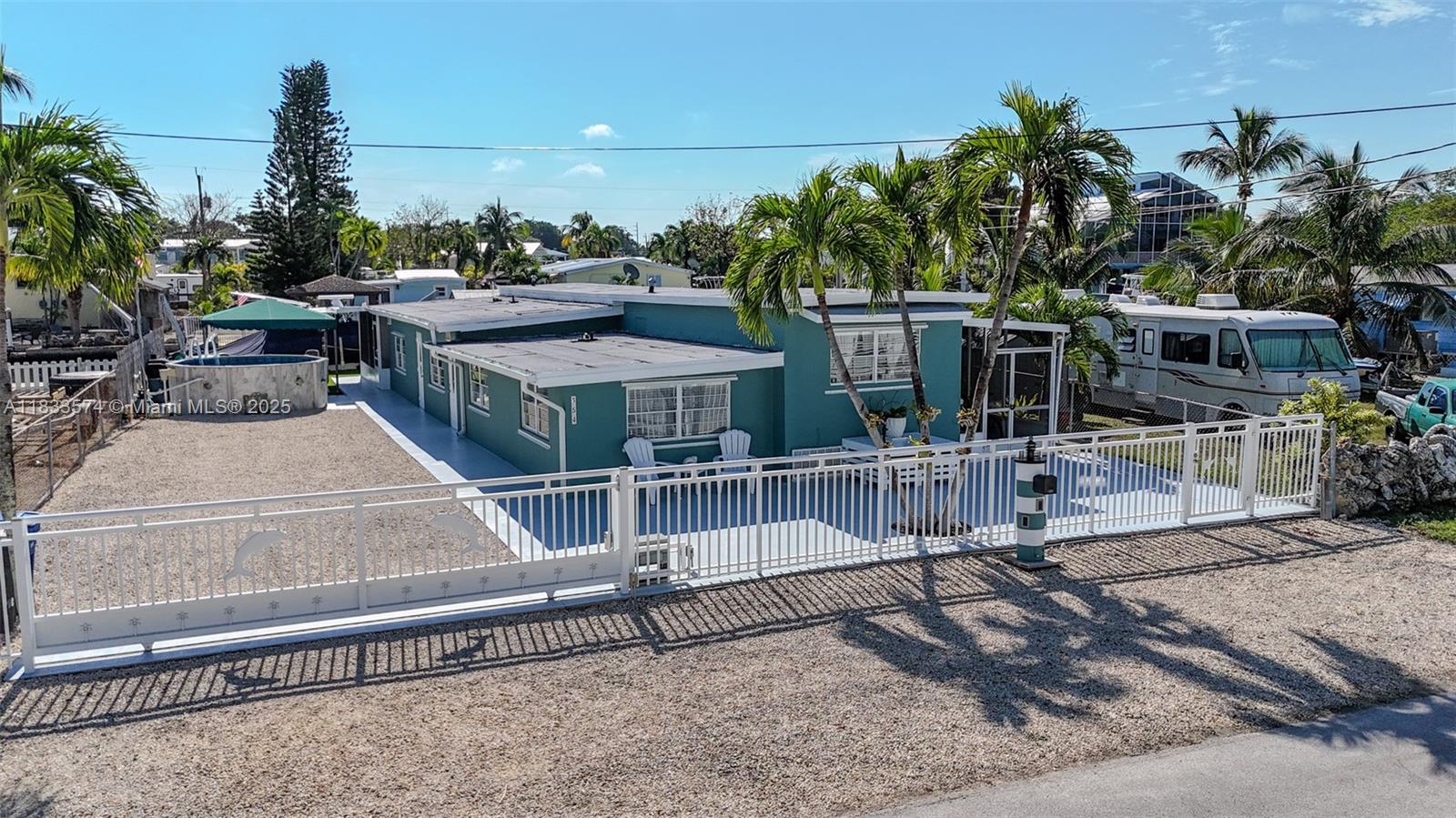 Price to sell, seller wants it gone! This home boasts 5 bedrooms and 3 bathrooms, providing plenty of space for large families. The outdoor space is a true oasis, featuring an above-ground pool, a fully fenced yard with an electric gate for privacy, and a charming gazebo to unwind and enjoy the surroundings. Entertain in the sunshine with the convenience of an outdoor kitchen, perfect for hosting gatherings. The property is equipped with a 10K lb boat lift and davits, ensuring your watercraft is secure. The proximity to Miami adds to the allure of this Key Largo gem, providing the ideal balance of waterfront living and easy access to the city. Your dream home awaits in Key Largo! Additionally, this home is a licensed vacation rental with future bookings in place.