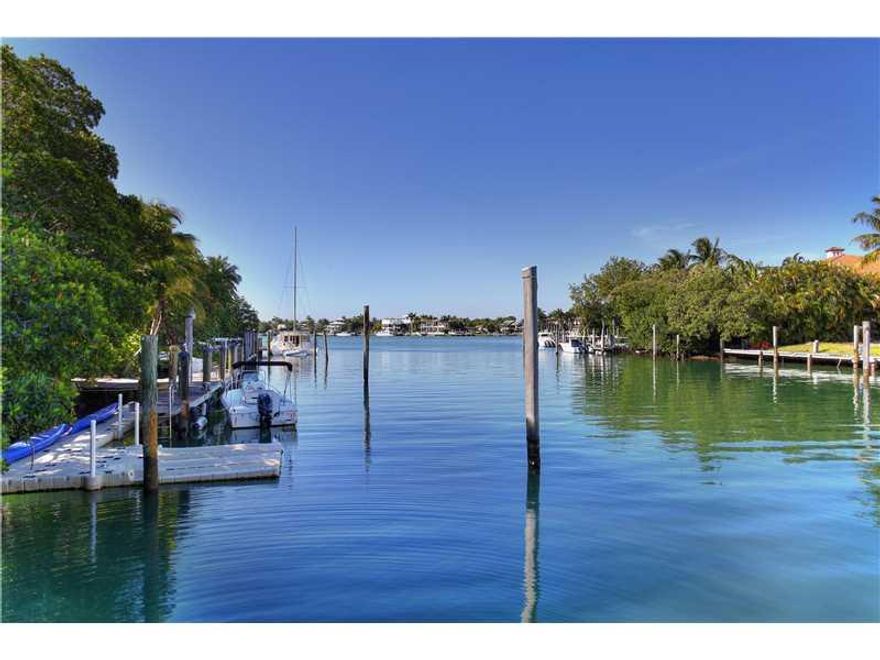 PRIVATE BEACH. One of the most charming KEY BISCAYNE cottage-style homes offering beautiful wide water view in Hurricane Harbor on beautiful private cove. Direct access to Biscayne Bay.  180 linear feet on the water. Large dock to accommodate your 80' yac ht. Private cove visited by manatees. Renderings of plans available for brand new home by Village Architechts. As per Village Architechts Company you can build a 5,649.4 SF residence (a/c space).