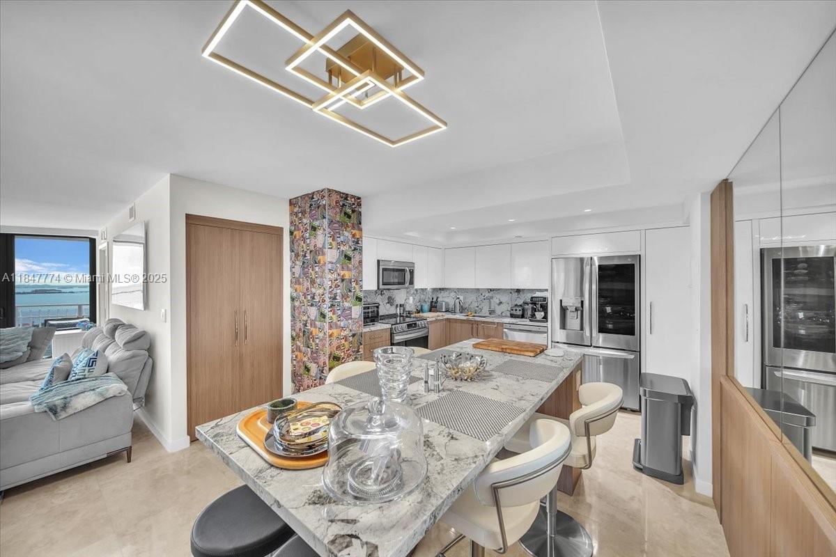 Step into this most impressive, newly redesigned unit on the top floor, facing South, with an extra-long balcony exclusive to the Tower Suite, featuring impact windows and doors—oversized eat-in kitchen for 6. Enjoy preparing food in a designated cooking space while your friends and family gather around the serving station, complete with built-in wine storage and space for a coffee and espresso bar. All high-end designer finishes. Whimsical NY art deco comic stripe tiles, elegant lighting, granite counter-tops, medicine cabinets, and a soaking tub. See brokers remarks
