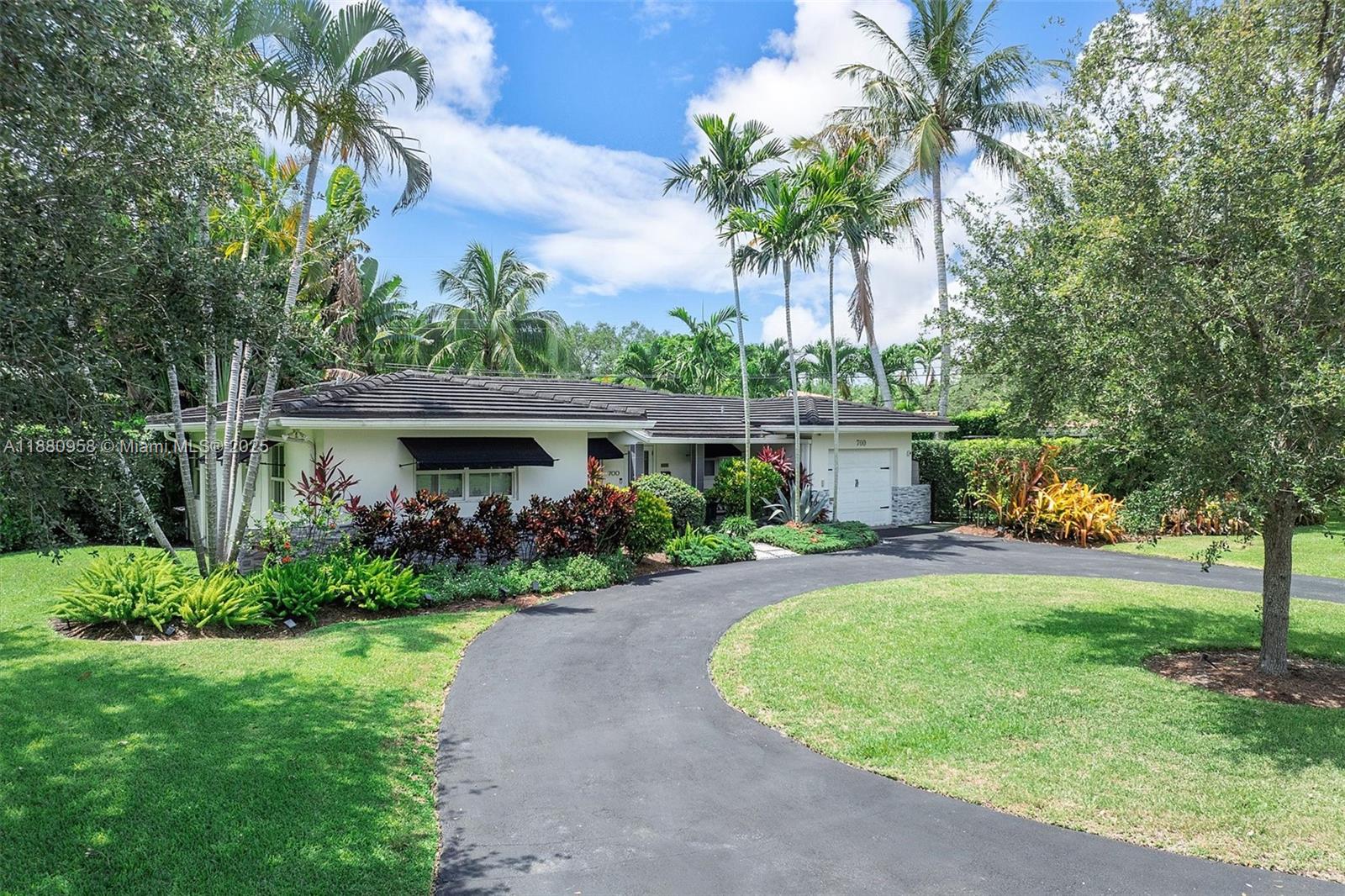 This beautifully updated home blends modern elegance with tropical charm, creating a true sanctuary. The open layout features sunlit living spaces and a gourmet island kitchen with Sub-Zero and Thermador appliances. The primary suite stuns with a glass-walled soaking tub, warm brick, and pebble stone accents. A third bedroom has been transformed into a spectacular custom closet. Enjoy three serene outdoor spaces, a separate office, impact windows/doors, newer roof, new AC, and all-new plumbing. As turnkey as it gets—just move in and exhale.