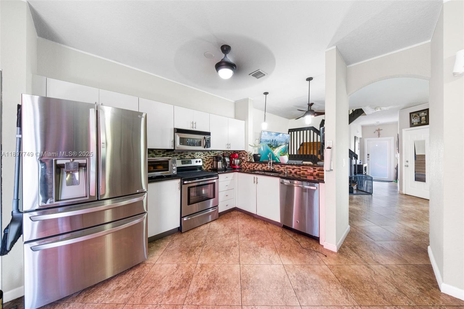 Light-filled Spacious 4BD/2.5BA corner townhome located on a dead end street with a large, fenced large backyard and serene water view. The open-concept layout features freshly painted kitchen, brand-new roof & gutters (2025), impact windows upstairs and garage door. Interior highlights include large tile flooring downstairs and bamboo laminate upstairs, updated bathrooms, and a generous primary suite with a walk-in closet. Appliances are updated and newer. Low-fee HOA includes ADT security and scheduled exterior painting in 2026. Conveniently located near parks, schools, and city community amenities.