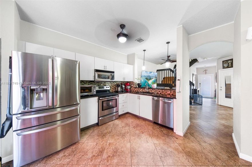 Light-filled Spacious 4BD/2.5BA corner townhome located on a dead end street with a large, fenced large backyard and serene water view. The open-concept layout features freshly painted kitchen, brand-new roof & gutters (2025), impact windows upstairs and garage door. Interior highlights include large tile flooring downstairs and bamboo laminate upstairs, updated bathrooms, and a generous primary suite with a walk-in closet. Appliances are updated and newer. Low-fee HOA includes ADT security and scheduled exterior painting in 2026. Conveniently located near parks, schools, and city community amenities.