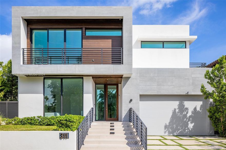 Nestled in the prestigious Golden Shores neighborhood of Sunny Isles Beach, this stunning residence at 311 189th Street presents an unparalleled opportunity for luxurious Florida living. Boasting an expansive layout spanning approximately 4,093 SF, this newly built, 5 bedroom/5.5 bathroom contemporary masterpiece offers a seamless blend of sophistication & comfort. The open-concept layout connects the living room, dining area, & gourmet kitchen with top-of-the-line appliances and a marble waterfall island. The backyard oasis includes lush landscaping & a sparkling pool, while the rooftop deck features the addition of solar panels + a summer kitchen offering 360° water views of the sunrise to the East & sunset to the West.