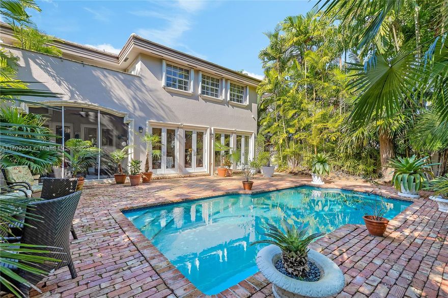 Exquisite Ponce Davis! With picturesque ambiance. This expertly crafted design harmoniously blends w/nature as showcased through a luminous, fluid flr plan. Indulge in elegant entertaining w/in the expansive LR, enhanced by soaring 22' ceilings, while the formal dining room adds a touch of sophistication. Top-of-the-line kitchen features high-end appliances and a cooking island, seamlessly connecting to the open family room w/stunning views of the spacious pool patio, adorned w/Chicago brick. A luxurious primary suite offers a tranquil retreat with a graceful bath and a private terrace nestled among the treetops. There are 3 Bdr Up and 1 Dwn, all with en-suite bths. The roof was recently replaced, and the home is equipped with complete impact glass doors and full wind mitigation measures.