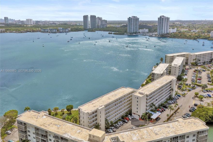 Spectacular unobstructed wide water views from every room of this 1st floor corner condo. Completely renovated with top of the line finishes. 48" porcelain slab floors throughout, impact windows/ doors, new A/C, tankless water heater, bluetooth enabled speakers & ambient lighting. New open kitchen with designer cabinets, quartz counters, stainless steel Samsung appliances, pull outs & custom pantry. Primary bedroom bright with extra windows being a corner unit, and also has a walk in closet + vanity area. New master bath with top notch appointments & custom tile work. 2nd bedroom also has a walk in closet and amazing water views. 2nd bath boasts all new high end finishes and tile work. Paradise is out back in the wrap around screed patio where you can take in the breathtaking forever water views and there's even an area for your own plantings. Then step out to waterfront walking trails, piers, benches, boats, greenery and flowers. Great amenities include 5 pools (next door is  the large heated pool).  Enjoy the clubhouse with social activities, movies, dancing, billiards, ping pong, bocce and more. Located close to shopping, restaurants, beaches, airports, casinos, the Aventura mall and more. Assessment Paid in full.  Lobby Redone. Excellent parking space in front. Vacant easy to show.