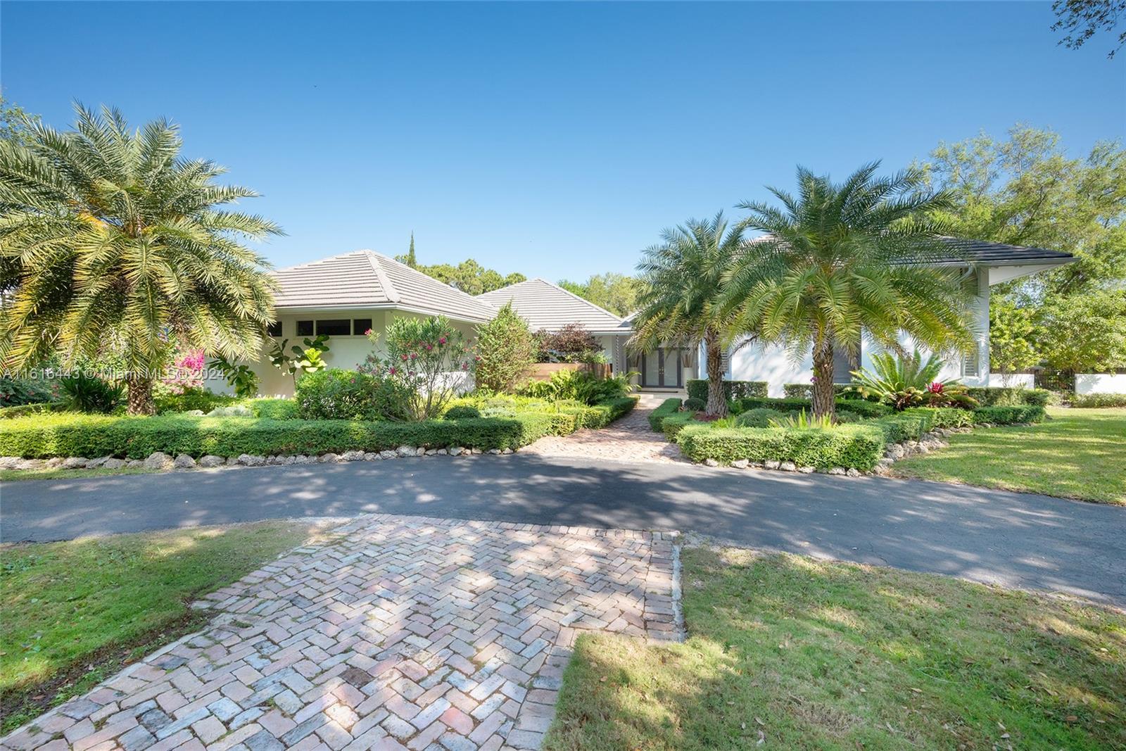 Welcome to paradise. This home is a true hidden gem located on a quiet/beautiful street w/privacy gates & is enveloped by exotic green grounds on almost 1.5 acres of land. Home has been remodeled w/pure elegance. Comes w/imported Jerusalem marble floors, high ceilings, bar/game rm, chef's kitchen, breakfast area, tons of natural light, impact win/doors, E/V charging station, water purifier sys & top of the line custom finishes. Features an add'l 1000sqft (2018) 1/1 Guesthouse w/its own kitchen/living/dining & W/D. Enjoy the Spanish glass tile saltwater pool, tennis crt, tiki hut & pergola w/summer kitchen. The ultimate indoor/outdoor living experience awaits you w/a resort-style feeling. Close to Riviera, Gulliver, Temple Beth Am & more!