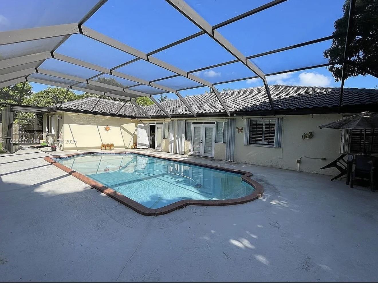 Stunning 5-Bedroom Home on a Peaceful Private Cul-de-Sac. This spacious home blends elegance, comfort, and functionality — perfect for family living and entertaining. Step inside to an open, light-filled layout featuring a separate living room, formal dining area, and an expansive Florida room that opens to the backyard oasis. The remodeled kitchen showcases sleek modern finishes. Throughout the home, plantation shutters and accordion hurricane shutters. Enjoy the best of Florida living outdoors with a screened-in pool, an oversized covered terrace with soaring ceilings, and a large patio surrounded by lush landscaping. The backyard also features a variety of fruit trees .Converted garage of, a circular driveway with generous parking, a new roof, and a large storage shed. With no HOA.