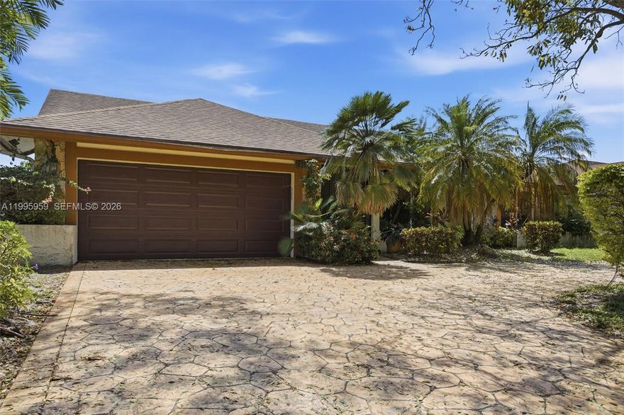 An outstanding 3 bed 2 bath north facing lake property, with beautiful upgrades, big back yard and large lake deck! As you enter this unit from a palm lined street and face its semi-circular driveway with plenty of foliage, the excitement builds.  You can’t help but notice the stunning grey wood-like tiles throughout the living areas and the elegant wine bar to your right. A formal dining section with a great view of the lake is right there. Next is the spectacular remodeled kitchen with white cabinets, Frigidaire appliances and black & white mottled countertops.  The family room boasts built in cabinetry and a TV above a fitted wall unit with quartz top! Both bathrooms are completely remodeled with lovely fixtures, soft close cabinets, wall tiles, solid countertops and captivating details. Your master is a wonderful, well-lit haven with double customized closets, double basins, a glass enclosed shower and lovely solid counters. The bedrooms have engineered wood floors, and the home has nice ceiling fans/lighting in every room. It’s completed with impact windows, a caged porch at back, large back yard with space for a pool plus huge deck for enjoying the lakeside. This close nit community is in Davie where everything is nearby. This home is a gem for anyone who wants a move in ready lakeside residence. There is no HOA and only a $250 annual fee for lake maintenance.