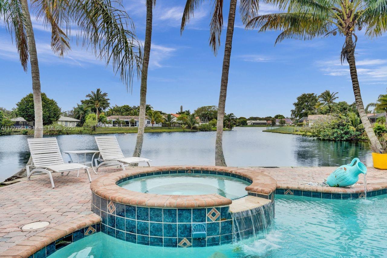 Enjoy stunning water views from this exceptional property, located directly in front of Michigan Lake—one of the most beautiful lakes in Jacaranda Lakes. Relax by the heated and cooled pool with a hot tub, all easily controlled by a remote. The home features a **new refrigerator**, **new washer**, **new pool motor**, **new pool filter**, a newer 50-gallon water heater, a new dishwasher, AC (2016). Impact patio doors and accordion shutters The split-level floor plan offers functional living in a fantastic neighborhood, centrally located in Broward County. Residents can enjoy Jacaranda Lakes Park, which has a playground, athletic courts, and walking trails. With a low HOA fee of just $52/month, this home perfectly combines comfort, convenience, and affordability.