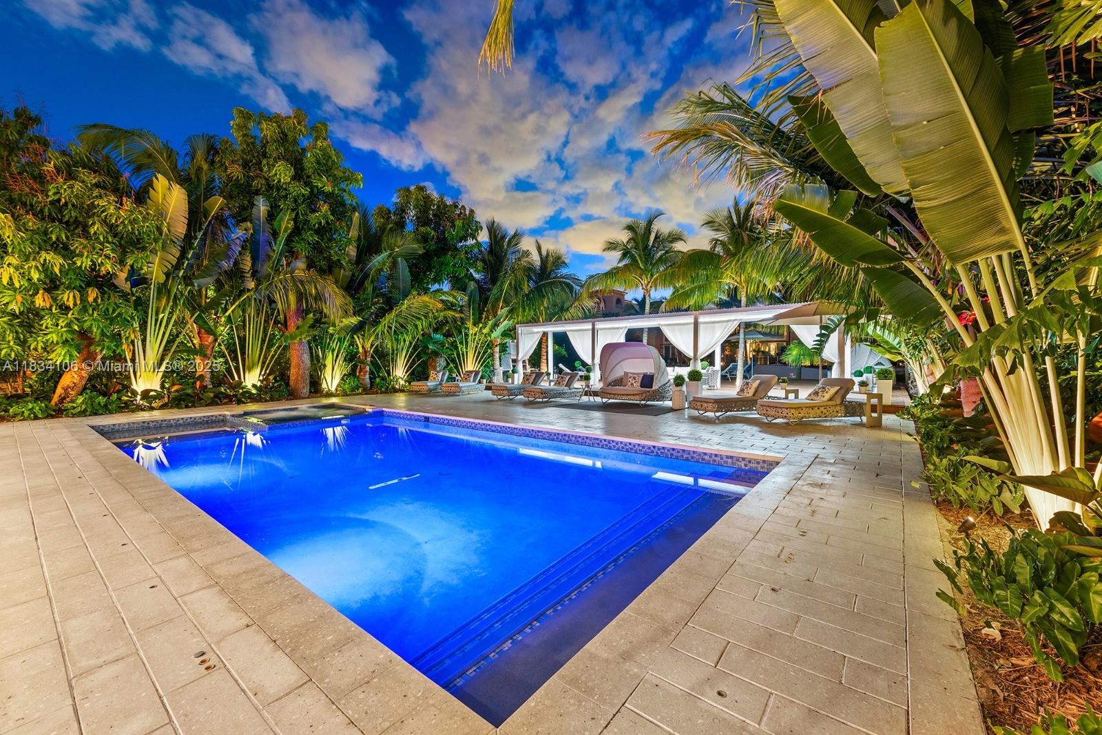 Luxurious 8-bed, 8.5-bath waterfront villa in Miami Beach’s Bayshore, newly built with 6,700 sqft interior and 14,000 sqft total. Steps from Biscayne Waterway, it’s close to top attractions. Enter through a breezeway to a grand great room blending dining, living, family, and a large eat-in kitchen with stunning water views. The master suite boasts a spa-like bathroom and private balcony overlooking the pool and water. Enjoy resort-style living with an infinity hot tub, expansive deck, privacy pergola, and premium patio furnishings. Near Miami Beach Golf Course and Sunset Shops, it’s minutes from Mid-Beach sands and world-class dining. Relax on the dock with cocktails at sunset