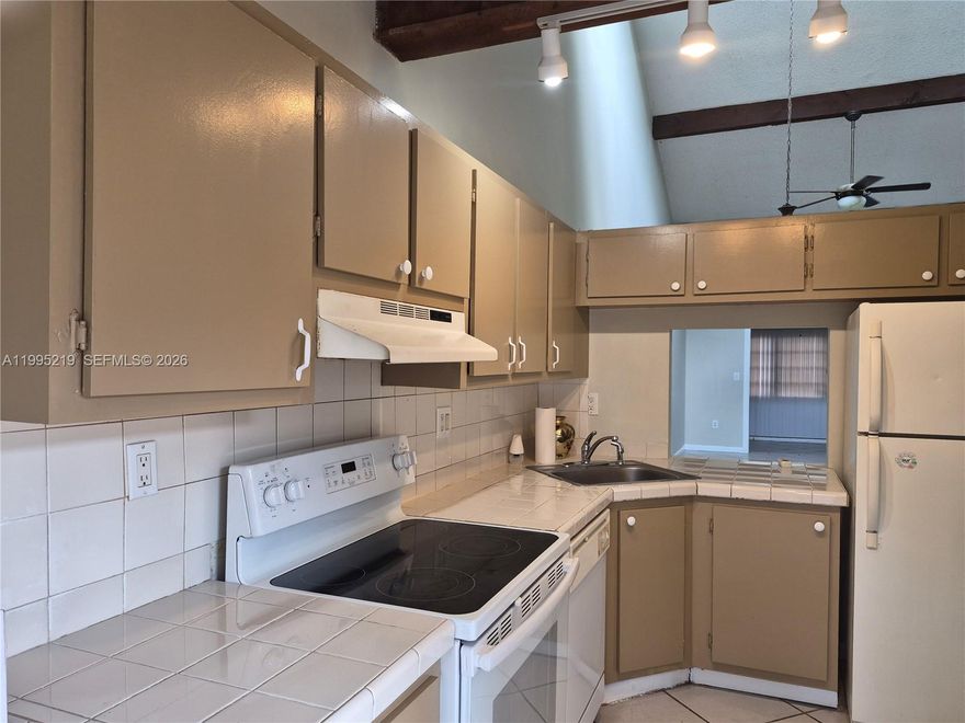 Great opportunity to live in the heart of Plantation. This community is undergoing an impressive transformation, featuring a new roof, new exterior siding, and fresh paint. This spacious two-bedroom townhome includes a den, a large eat-in kitchen, and vaulted ceilings with skylights that fill the space with natural light. The expansive primary suite offers a walk-in closet and a private en-suite bathroom. Enjoy outdoor living in the fenced backyard, perfect for relaxing or entertaining.