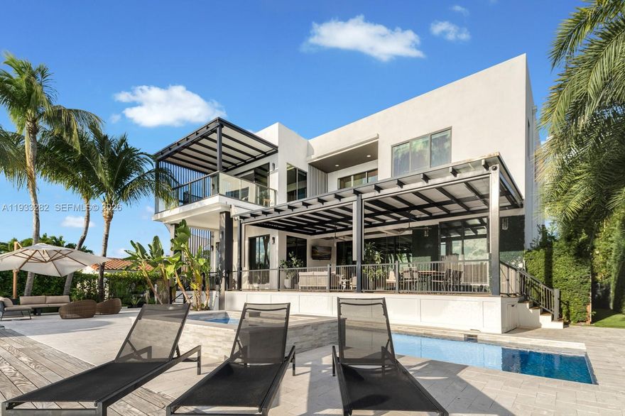 Welcome to resort-style living, where boutique-hotel outdoor spaces set the stage for everyday luxury. Angled bay views and Miami skyline vistas define this waterfront residence.  Enjoy all-day outside beneath the expansive covered Brazilian-wood deck or in full sun by the lap pool with baja shelf and jacuzzi. The deck and thoughtful architectural details were curated by renowned architect Leo Shehtman.
Nestled on a quiet cul-de-sac in the gated Estates of Sans Souci, this beautifully crafted residence features a grand double-volume entry and soaring 12’ ceilings throughout. The living space designed for comfort and entertaining, offers 6 bedrooms, office, 7 bathrooms, a pajama lounge plus a Lutron Homeworks system.
For the car enthusiast, the 2-car garage offers  tandem height and easily adapts to 4-car capacity, secured with a private gated entry. Ample storage and elevator-ready design provide future flexibility.
The Primary Suite features a spacious covered terrace overlooking the bay. This is the ultimate boat lovers lifestyle with no fixed bridges, 75 ‘ of waterfront, 20,000 boat lift,  and fast ocean access.
Enjoy the best of both worlds: serene waterfront living with unmatched mainland convenience, minutes to Bal Harbour, The Beach, Indian Creek, the Design District, and Aventura., A seamless blend of refined interiors and resort-style outdoor living