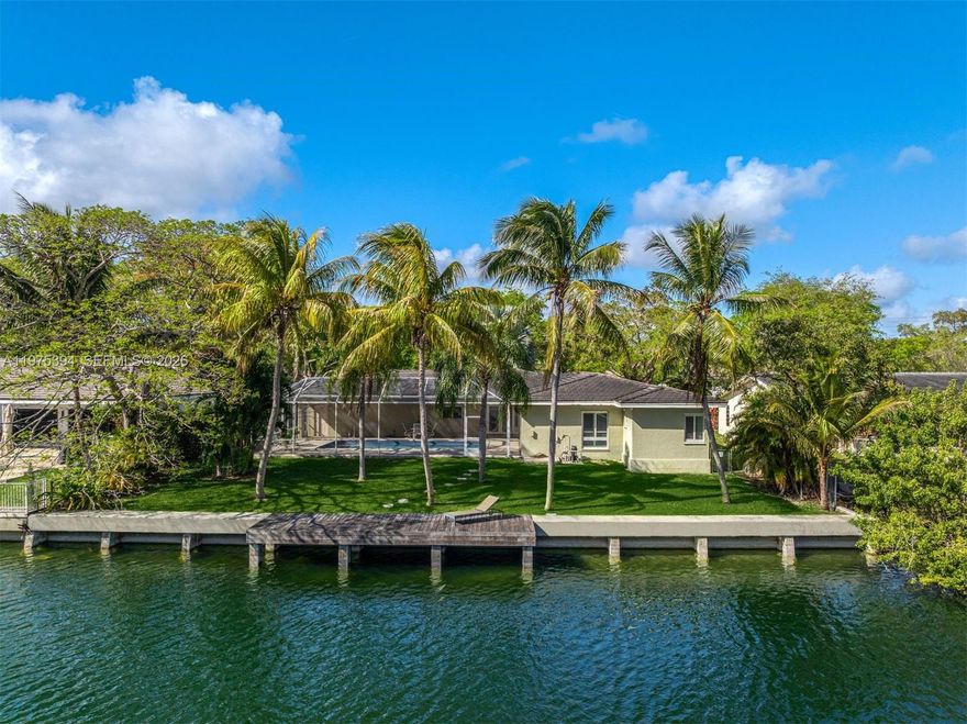 Nestled in the gated community of Gables by the Sea, this 4 bd 3 ba canal-front residence offers 100' of freshwater on a 12,300 sf lot with a circular brick driveway, creating a peaceful setting surrounded by lush landscaping & mature palm trees. This light-filled home offers an opportunity to refresh the existing charm of this well-constructed 1972 ranch style beauty. The floor plan includes 2 ensuite baths & generously sized closets. The gracious foyer entry welcomes you to formal living & dining areas & a family room w/direct pool/veranda access. The spacious white kitchen features a convenient pass-through bar opening directly to the pool/veranda & ready for new owner personal touches. Additional highlights include impact glass & custom plantation shutters. A 2-car garage includes a laundry area with washer/dryer & utility sink. Outdoor living is peaceful & inviting, featuring a screened 30x15 pool overlooking the freshwater canal, a veranda w/ceiling fans, & cabana bath for added convenience. The lush yard offers plenty of green space to relax & play while enjoying tranquil waterfront views. The private seawall and dock create the perfect launch point for paddle boarding, kayaking, or canoeing on the freshwater. No ocean access. Ideally located near the area’s finest parks, marinas, and amenities. Residents of the gated community also enjoy a neighborhood park with a playground, gazebo for gatherings, open grass field, and basketball court, all near top-rated schools.