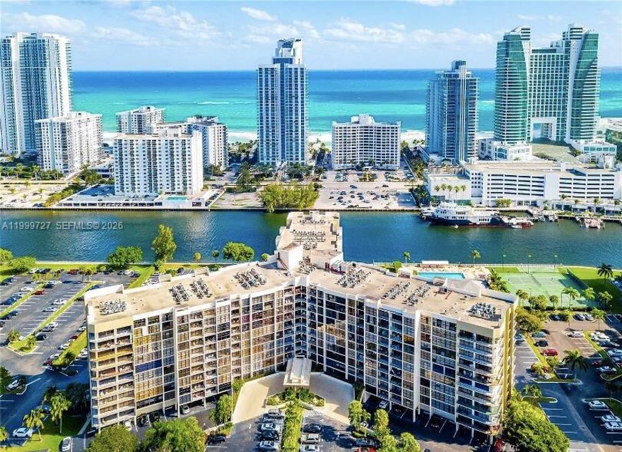 Designer remodeled 2 bedroom, 2 bath condo with luxurious custom finishes, on the charming Three Islands! Ground floor. Low HOA: $707/mo! Deeded parking spot (own it/can rent out). 2 private tennis courts (with night lights) that overlook yachts going by on the intracoastal! Pool, gym, yoga room, billiards room, shuffleboard courts! 24/7 security. Central A/C, new water heater (April 2026). Luxurious oversized 36" x 36" matching tile throughout, open floorplan kitchen with "waterfall" peninsula, matching stainless steel appliances, oversized fridge with built in water filter, pull out faucet, remote controlled roller shades on windows, huge bath tub, stylish "floating" bathroom vanities with designer faucets, LED lights, soft close cabinets (in kitchen, bathrooms), soft close toilets.