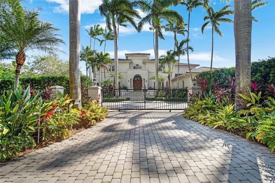 Manicured landscaping with mature trees provides the ideal setting for this stunning Architectural Masterpiece. Sweeping steps beckon you into the grand foyer, with its elegant staircase. Marble floors, volume ceilings, oversized windows, and finely crafted millwork can be seen throughout. This custom home offers a private Primary Suite; a retreat unto itself with a spacious bathroom and gym.  Guests will enjoy their separate downstairs quarters, with covered patio and pool access. The great room overlooks the tropical grounds, complete with a generous size pool and (trendy) pickleball court. Enjoy Florida living at a different level. This gem has been meticulously maintained by the original owners. A must see!