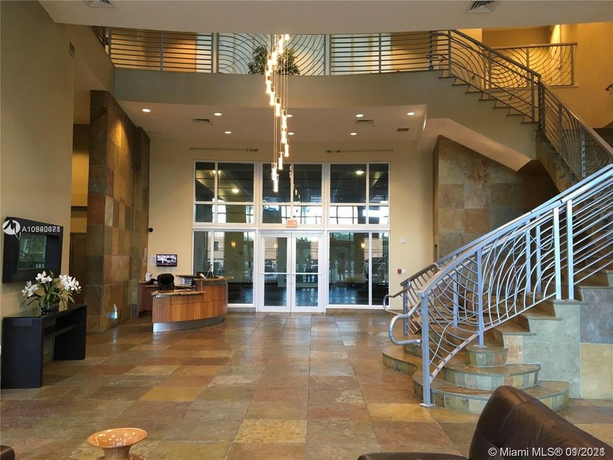 Unique 2 story condo at ground level with 20sf high ceilings in living room with floor to ceiling windows. 3/3.5 with den including 2 private patio/terraces. 2262 sf of total living area with 3 parking spaces (2 assigned and 1 valet)Amenities include, pool, spa, gym, movie room, business/conference room, social room, jogging tracks next to the tennis course located on 7 floors. 24hrs valet services/concierge, guard at the gate.