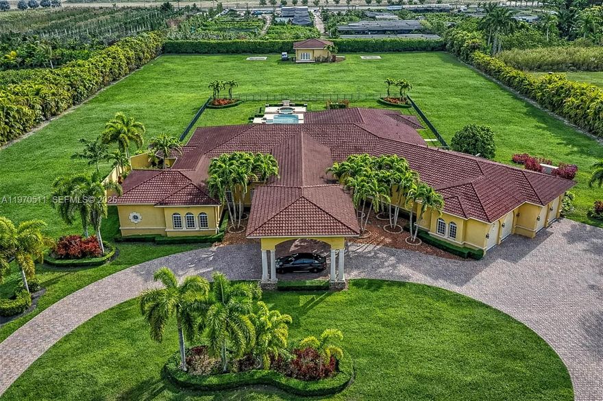 Private double gated estate home set on over 4.8 acres, this exceptional property offers 9,943sqft of living space with a well-designed triple split floor plan. The main residence features 6 bedrooms plus an office including a master and jr. suite, 7.5 baths, chef's kitchen with double subzero refrigerators, double subzero freezers, subzero drink drawers, double miele ovens, built in miele coffee maker, subzero wine refrigerator and expansive island and counter seating. Windows and doors all PGT impact glass.  Metal roof on main house and rear structure. Lutron low voltage lighting, Control4 sound system and Cat6 wiring throughout the home. Full home Kohler 45kw generator. Designed for both entertaining and everyday comfort, the home includes a private theater, built-in bar, covered patio with summer kitchen, and a resort-style pool and spa. The expansive primary suite offers dual custom walk-in closets, large shower, and jetted tub. Jr suite boasts dual walk-in custom closets, double vanity bathroom, a shower/tub combo and a separate shower. A true highlight is the oversized four car dream garage with double-height ceilings, plus a detached mini-split AC temperature-controlled building currently used as additional garage space and a custom gym, with a powder room. A rare opportunity combining privacy, scale, and luxury built to the highest standards.