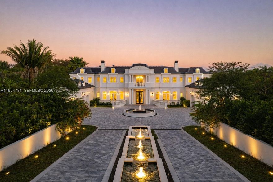 Set behind a grand approach with a long circular driveway and a dramatic 90+ foot cascading water fountain, Chateau du Soleil showcases award winning architecture by Ramon Pacheco. Timeless French château elegance meets modern luxury with soaring ceilings, marble floors and baths, fireplaces, dormer windows, and exquisitely detailed wall finishes throughout. A custom two-story library anchors the home, complemented by a private theater, gym, residential elevator, staff quarters, and three staircases. The primary suite offers massive walk-in closets and a private terrace, while additional suites enjoy balconies with serene views. Resort style grounds feature lush lawns, koi pond, covered terraces, full summer kitchen, gazebo with fire pit and cabana bath, plus room for a future sports court. Ideally located near elite Pinecrest schools, this is a rare legacy estate for refined living and grand entertaining.