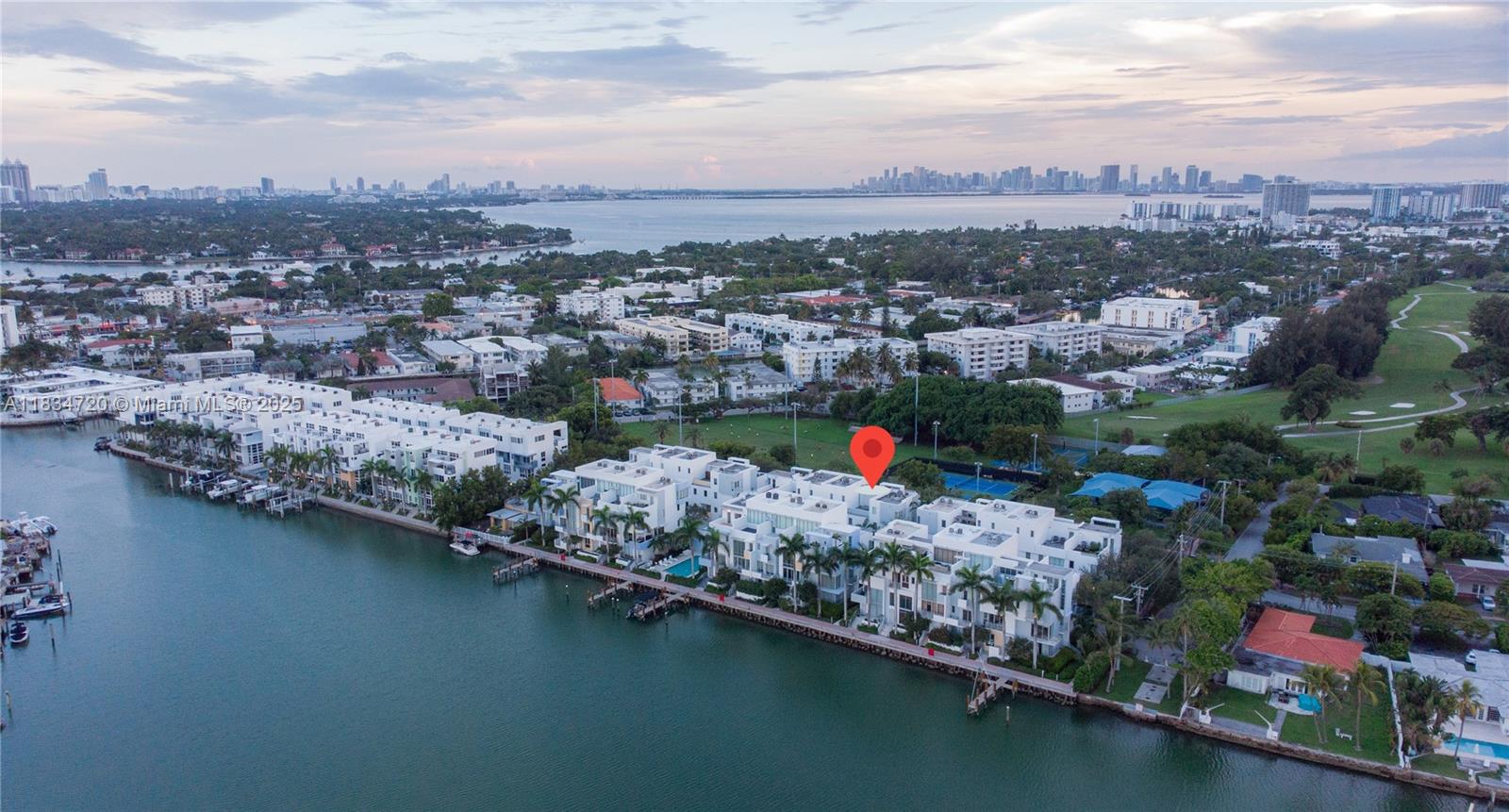 Live in this beautiful contemporary 4 story townhome located in a picturesque waterfront community, just minutes from the beach. Featuring two large rooftop terraces, a 2-car garage (+ 1 outdoor parking), and access to a waterfront pool. Upon entry, you're welcomed by soaring 18-foot ceilings in the living room, flooded with natural light from floor-to-ceiling windows. The open kitchen and dining area on the second floor create a seamless space for everyday living and entertaining. The third floor features two spacious master suites for ultimate privacy and relaxation. Enjoy morning coffee or sunset barbecues from either of your private rooftop terraces, with scenic views as your backdrop. Located right across from Tennis courts and Normandy Golf Course is just a golf cart ride away.