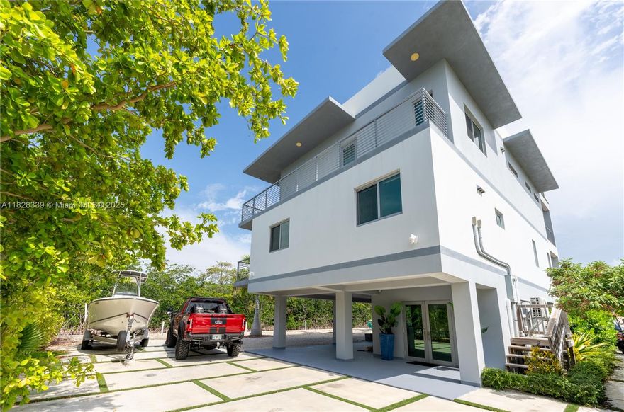 Experience unparalleled luxury in this stunning 2020-built modern home,located on a corner lot with over 200 feet of waterfront.This masterpiece spans four stories, featuring sleek finishes and a gourmet chef's kitchen with a quartz waterfall island.Enjoy the rooftop oasis with new turf and spiral staircase access,offering stunning views.The expansive outdoors includes a full kitchen,an 80-foot dock with a 20k LB Neptune boat lift,and 125 feet of seawall.Approved pool plans available.This boater's paradise provides direct bay and ocean access via Jewfish Creek or Adams Cut.Additional features include a mosquito misting system and elevator.Sold fully furnished,it’s an amazing investment opportunity for short-term rentals or to own an extraordinary Key Largo estate.Ready to explore this gem?